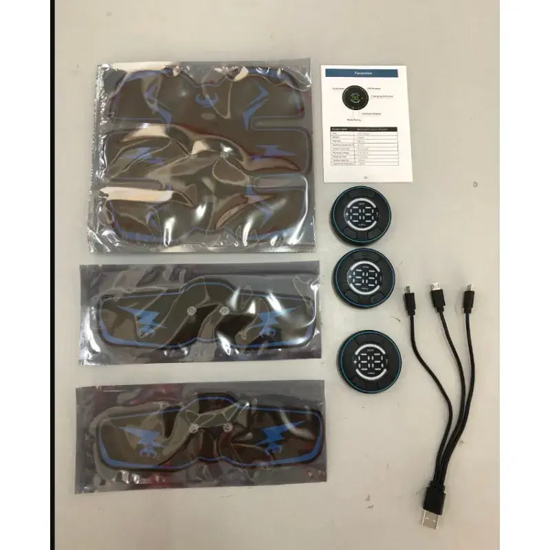 Components of Smart EMS Muscle Stimulator kit including pads, connectors, and instructional guide.